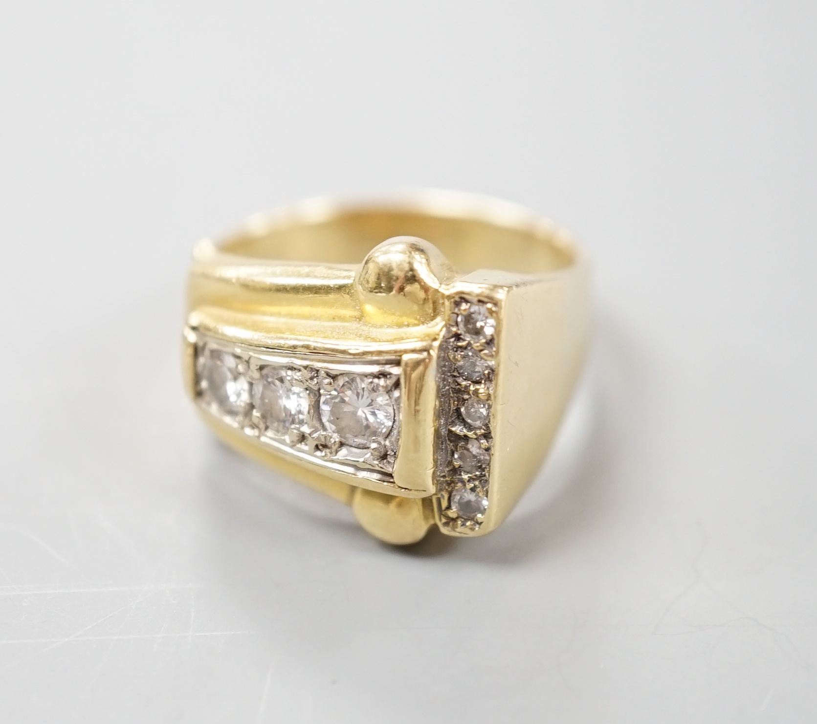 A 1950's yellow metal and graduated eight stone diamond set dress ring, size P/Q, gross 10 grams.